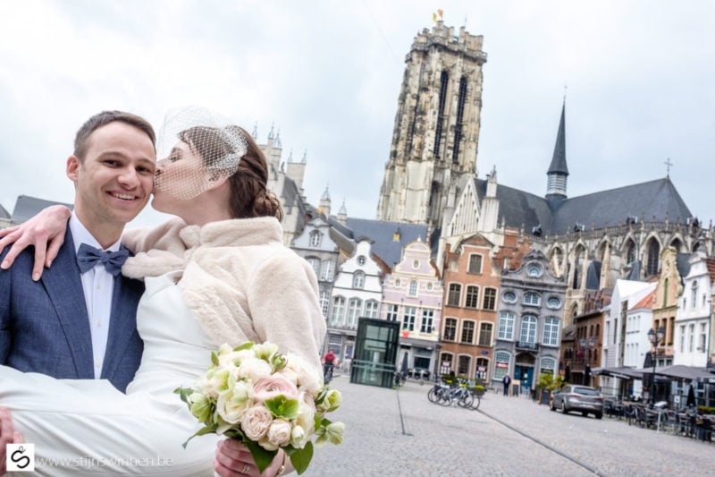 Huwelijksreportage in centrum Mechelen met op achtergrond de lege Grote Markt en Sint-Romboutstoren